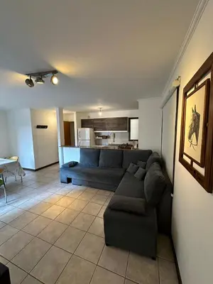 a living room with a couch and a kitchen at Departamento 1 dorm amoblado Nueva Córdoba 6 E INVERHOME INMOBILIARIA in Cordoba