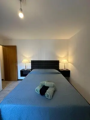 a bedroom with a large bed with a blue blanket at Departamento 1 dorm amoblado Nueva Córdoba 6 E INVERHOME INMOBILIARIA in Cordoba