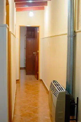 a hallway with a room with a television and a door at Le Bon Repos in Alta Gracia
