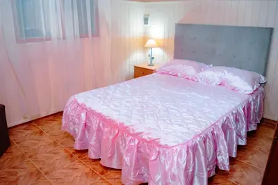 a bedroom with a large bed with a pink bedspread at Le Bon Repos in Alta Gracia