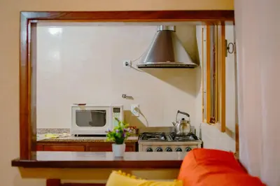 a small kitchen with a microwave and a stove at Le Bon Repos in Alta Gracia