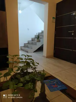 a living room with a potted plant and stairs at Casa 3 dormitorios. - Barrio Valle Cercano in Cordoba