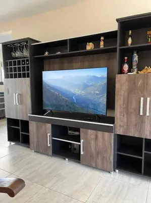 a large entertainment center with a flat screen tv at Casa 3 dormitorios. - Barrio Valle Cercano in Cordoba