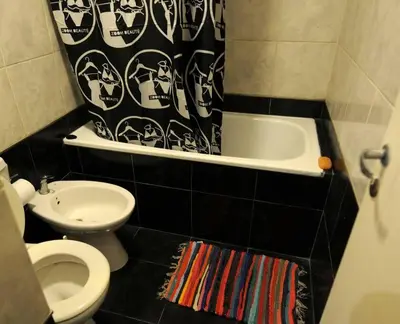 a bathroom with a toilet and a tub and a sink at Tu lugar en Córdoba. in Cordoba