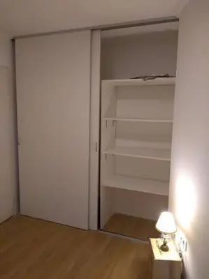a room with a closet with a lamp on a table at Tu lugar en Córdoba. in Cordoba