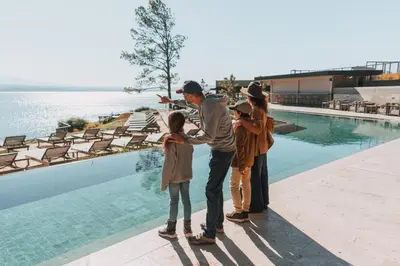 a man and two children standing by a swimming pool at Get Hotel Molvento, AKEN SOUL Collection in Villa General Belgrano