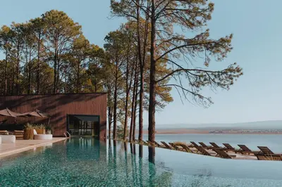 a swimming pool with chairs next to a body of water at Get Hotel Molvento, AKEN SOUL Collection in Villa General Belgrano