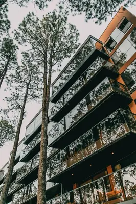 a tall building with trees in front of it at Get Hotel Molvento, AKEN SOUL Collection in Villa General Belgrano