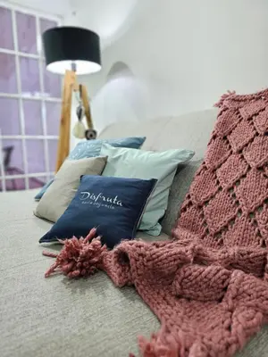 a bed with a pink knitted blanket and a lamp at MilcaCeleste Nueva Cordoba II in Cordoba