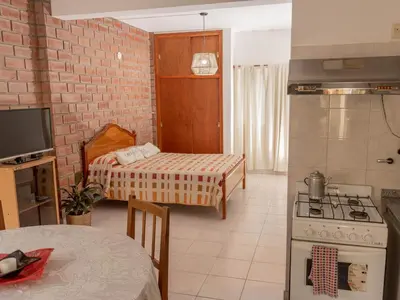 a kitchen with a stove and a room with a bed at Depto 2 in Villa Carlos Paz