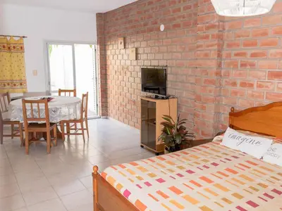 a bedroom with a brick wall and a bed and a table at Depto 2 in Villa Carlos Paz