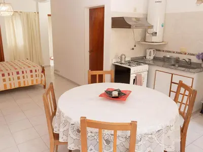 a kitchen with a table and chairs and a kitchen with a stove at Depto 2 in Villa Carlos Paz