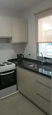 a kitchen with a stove and a sink at Departamento Opera Torre 2 in Villa Carlos Paz