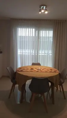 a dining room table with chairs in front of a window at Departamento Opera Torre 2 in Villa Carlos Paz