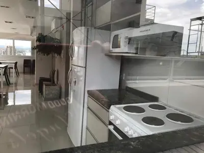 a kitchen with a white refrigerator and a stove at Departamento Opera Torre 2 in Villa Carlos Paz