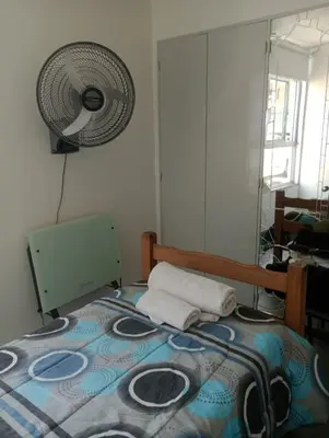 a bedroom with a bed with a fan on the wall at La casa de Emma in Cordoba