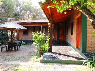 a porch of a house with a table and a umbrella at Alma Mora in Merlo
