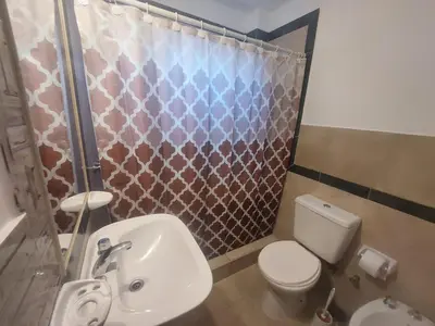 a bathroom with a toilet and a shower curtain at Alma Mora in Merlo