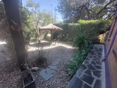 a garden with a table and a gazebo at Alma Mora in Merlo