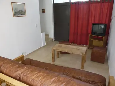 a living room with a couch and a table and a tv at Dúplex El Ceibo in Villa Carlos Paz