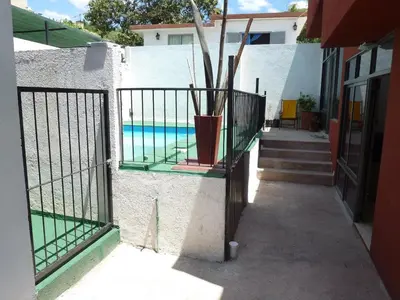 a fence with a potted plant next to a pool at Dúplex El Ceibo in Villa Carlos Paz