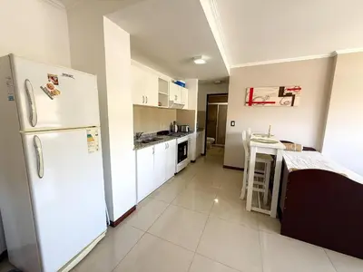 a kitchen with a white refrigerator and a table at Veneto II in Villa Carlos Paz