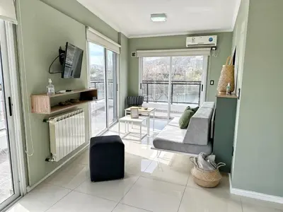 a living room with a couch and a tv in it at Veneto II in Villa Carlos Paz