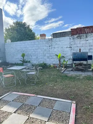 a backyard with a table and chairs and a brick wall at Monoambiente calamuchita in Santa Rosa de Calamuchita