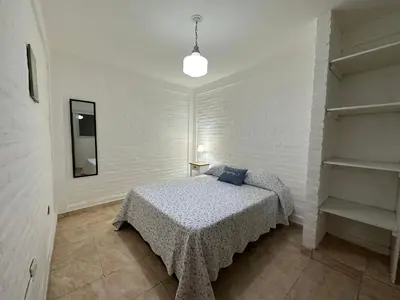 a bedroom with a bed in a white room at AGRADABLE Dpto. pasaje Tucumán in Alta Gracia