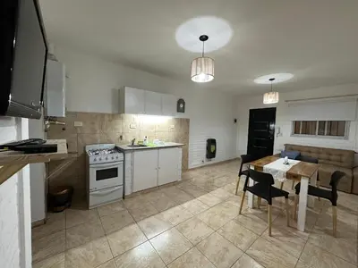 a kitchen and dining room with a table and a stove at AGRADABLE Dpto. pasaje Tucumán in Alta Gracia