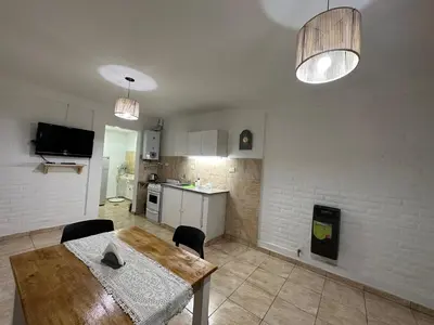 a kitchen and dining room with a table and chairs at AGRADABLE Dpto. pasaje Tucumán in Alta Gracia
