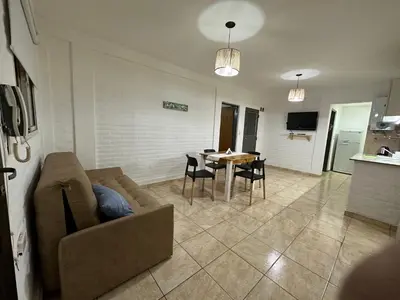 a living room with a couch and a table with chairs at AGRADABLE Dpto. pasaje Tucumán in Alta Gracia