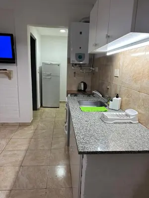 a kitchen with a sink and a refrigerator at AGRADABLE Dpto. pasaje Tucumán in Alta Gracia