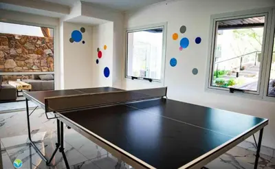 a ping pong table in a room with two windows at Departamento Veneto Village, Parque Siquiman, Carlos Paz in Villa Parque Siquiman