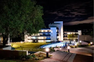 a large building with a pool in front of it at night at Departamento Veneto Village, Parque Siquiman, Carlos Paz in Villa Parque Siquiman