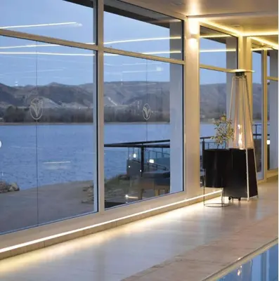 a house with a large window with a view of the water at Departamento Veneto Village, Parque Siquiman, Carlos Paz in Villa Parque Siquiman