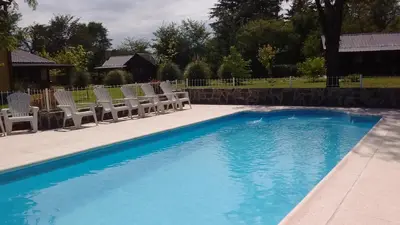a swimming pool with chairs and a swimming pool at Estilos Argentinos in Los Reartes