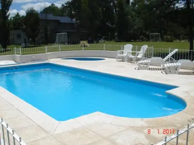 a large swimming pool with chairs at Estilos Argentinos in Los Reartes