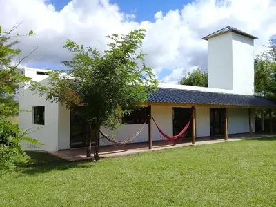 a white building with a hammock in the yard at Estilos Argentinos in Los Reartes