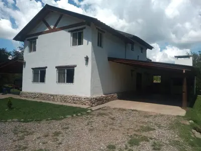 a large white house with a garage in a yard at Estilos Argentinos in Los Reartes