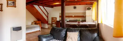 a living room with a couch and a kitchen at Estilos Argentinos in Los Reartes