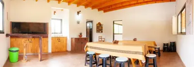 a room with a bed and a table and stools at Estilos Argentinos in Los Reartes