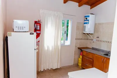 a kitchen with a white refrigerator and a window at Cabañas Susurros del Río in Trapiche
