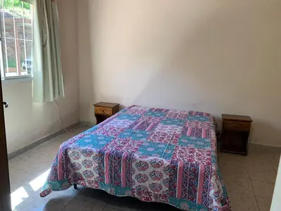a bedroom with a bed with a quilt on it at Cabañas Susurros del Río in Trapiche