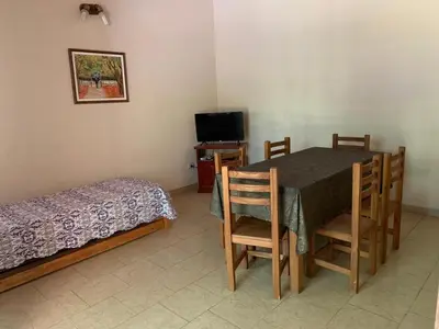 a bedroom with a table and a bed and a television at Cabañas Susurros del Río in Trapiche