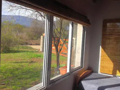a window in a room with a view of a yard at Sueño del Champaquí in Villa de Las Rosas