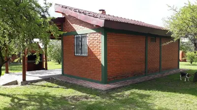 a small red brick building with a window at Dos Soles in Mina Clavero