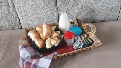 a basket filled with bread and a bottle of milk at Dos Soles in Mina Clavero