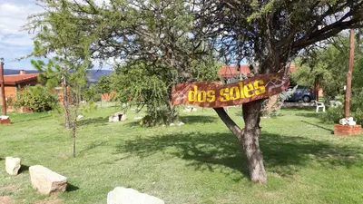 a sign on a tree in a yard at Dos Soles in Mina Clavero