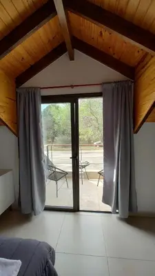 a bedroom with a bed and a large glass door at Duplex Zekkei in Villa General Belgrano